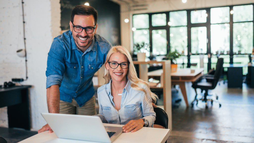 A couple in their retail store smiling at a laptop displaying successful marketing results